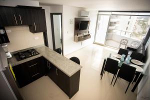 eine Küche und ein Wohnzimmer mit Theke und Tisch in der Unterkunft DEPARTAMENTO DE LUJO FRENTE AL MAR, WIFFI PISO 8 in Tonsupa