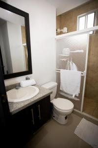 ein Badezimmer mit Toilette, Waschbecken und Spiegel in der Unterkunft DEPARTAMENTO DE LUJO FRENTE AL MAR, WIFFI PISO 8 in Tonsupa