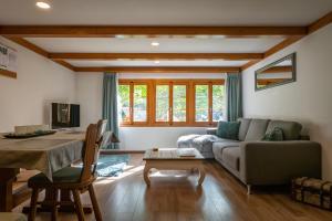 ein Wohnzimmer mit einem Sofa und einem Tisch in der Unterkunft Chalet Elza in Lauterbrunnen