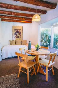 a bedroom with a bed and a table and chairs at Hotel y Termas Huife in Termas De Huife