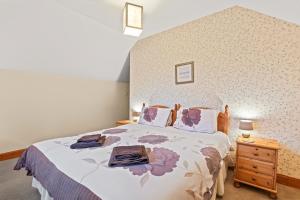 a bedroom with a bed and a wooden night stand at Freuchies Mill - A Holiday Home For All Seasons. in Blairgowrie