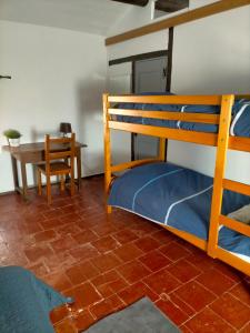 a bedroom with two bunk beds and a table at Chez Nath et Oli in Caunes-Minervois