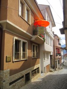 ein Gebäude mit einem orangenen Regenschirm auf einer Straße in der Unterkunft Apartments Stars in Ohrid