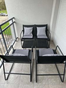 two chairs and a table on a balcony at Apartman 8 in Vrdnik