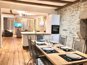 una cucina e un soggiorno con tavolo e sedie in legno di LE LAENNEC - GRAND T3 PLEIN CENTRE PIETON a Quimper