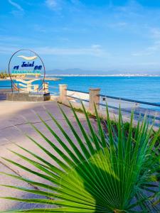 聖艾格夫的住宿－Villa climatisée calme avec piscine partagée Saint AYGULF/FREJUS，棕榈树在海滩前的海洋