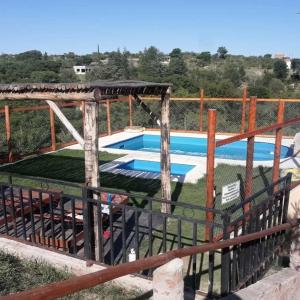 ein Schwimmbad mit einem Zaun um ihn herum in der Unterkunft Cabaña 2 in Cordoba