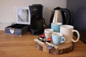 uma bandeja de madeira com 2 chávenas de café e comodidades para preparar café em LikeHome Apartment -3Rooms - 10persone -Ferrara em Ferrara