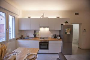 uma cozinha com armários brancos e um frigorífico de aço inoxidável em LikeHome Apartment -3Rooms - 10persone -Ferrara em Ferrara