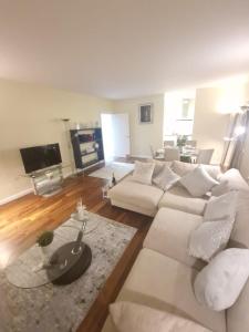 a living room with a white couch and a tv at Lux 2 Bed Flat in Canary Wharf in London