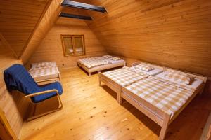 um quarto no sótão com 2 camas e uma cadeira em Chata Domaša - Nová Kelča em Valkov