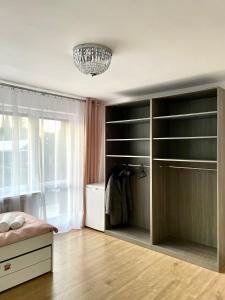 Beautiful rooms in Szczecin - parking Gratis في شتتين: غرفة نوم مع خزانة كبيرة مع رفوف سوداء