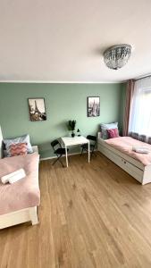 a living room with two beds and a table at Beautiful rooms in Szczecin - parking Gratis in Szczecin