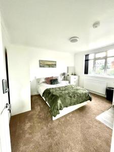 a bedroom with a bed with a green blanket at Studio 22 Lower Road Beeston in Nottingham
