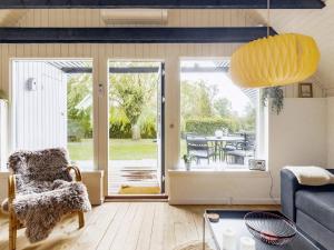 ein Wohnzimmer mit einem Sofa und einer Glasschiebetür in der Unterkunft Holiday home Karrebæksminde IX in Karrebæksminde