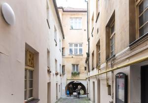 an alley between two buildings with people walking through it at Old Crooked Beams near Charles Bridge in Prague in Prague