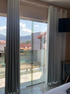 - une chambre dotée d'une grande fenêtre offrant une vue sur la piscine dans l'établissement Pousada Licuri Ibicoara, à Ibicoara