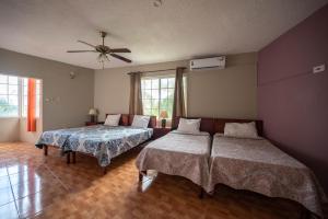 1 dormitorio con 2 camas y ventilador de techo en Chrisann's Beach Resort, en Saint Mary