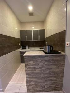 a kitchen with a counter with a stove and a microwave at بيوتات المروة للشقق المخدومة biutat almarwa in Jeddah