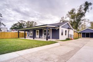 une petite maison blanche avec une clôture dans l'établissement Lake Charles Home with Gas Grill and Fenced-In Yard!, à Lake Charles