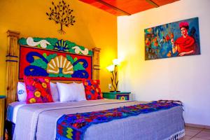 a bedroom with a large bed with a colorful headboard at Posada las Margaritas in Guadalajara