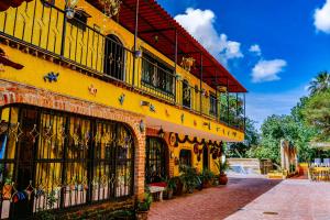 a yellow building with balconies on a street at Posada las Margaritas in Guadalajara