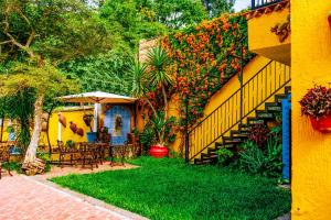 einen Garten mit einem Tisch, Stühlen und Blumen in der Unterkunft Posada las Margaritas in Guadalajara