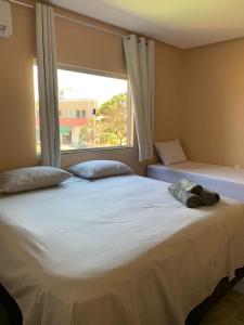 a bedroom with a large white bed with a window at Pousada Licuri Ibicoara in Ibicoara