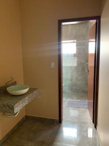 uma casa de banho com um lavatório e uma cabina de duche em vidro. em Pousada Licuri Ibicoara em Ibicoara
