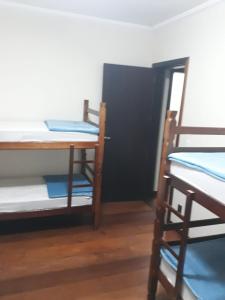 a room with three bunk beds and a door at Blu Hostel in Blumenau