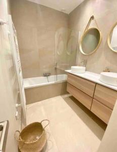 a bathroom with a tub and two sinks and a bath tub at Penthouse 2 bedrooms With Terrace & Free Parking in Luxembourg