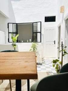 een woonkamer met een houten tafel en planten bij Ocean Home in Essaouira