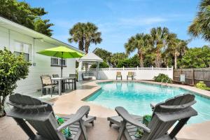 una piscina con sedie, tavolo e ombrellone di Beach house & backyard oasis with private pool - short walk to beach a Baptist Medical Center/Beaches Heliport