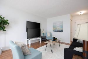a living room with a couch and a tv at Spacious 1BR with Parking and WiFi Near NLRHC in Fort McMurray