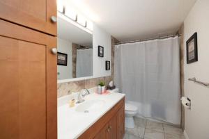 a bathroom with a sink and a toilet and a mirror at Spacious 1BR with Parking and WiFi Near NLRHC in Fort McMurray