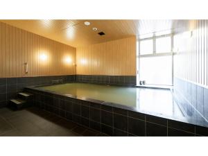 Una gran piscina de agua en un baño con ventana en TORIFITO HOTEL&POD NISEKO - Vacation STAY 81523v en Kutchan
