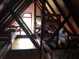 an attic room with several bunk beds and a window at El Refugio en la Quebrada in Quebrada de los Cuervos
