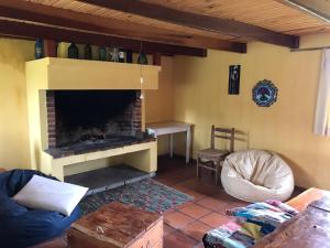 sala de estar con chimenea de ladrillo y silla en El Refugio en la Quebrada, en Treinta y Tres