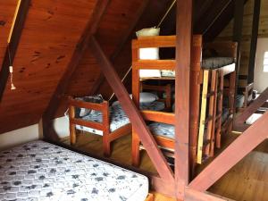 ein Dachzimmer mit einer Leiter und 2 Stühlen in der Unterkunft El Refugio en la Quebrada in Treinta y Tres