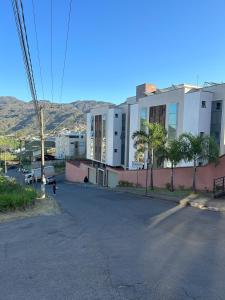 an empty street with a building and palm trees at Requinte e Conforto OP - MG in Ouro Preto