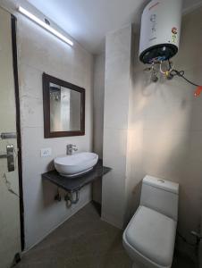 a bathroom with a sink and a toilet and a light at Hotel Aron By The Premium Villa in New Delhi