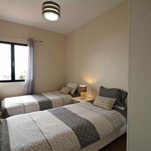 a bedroom with two beds and a window at Pedreira apartment in Calheta
