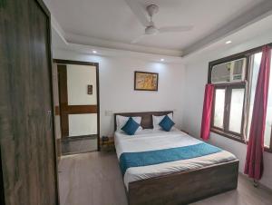 a bedroom with a bed with blue pillows at Hotel Aron By The Premium Villa in New Delhi