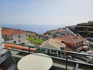 a balcony with a white table and some buildings at Pedreira apartment in Calheta