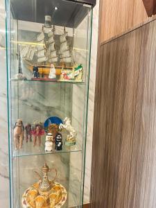 a glass cabinet filled with toys and other items at TAMARIND HOTEL in Dubai
