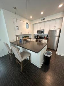 a kitchen with a large island with chairs and a refrigerator at Amazing 2BD2BA located DTLA in Los Angeles