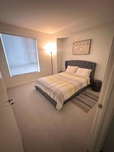 a bedroom with a bed with a lamp and a window at Amazing 2BD2BA located DTLA in Los Angeles