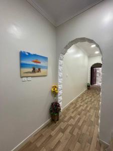 a hallway with an archway with a painting and flowers at وحدات صروح الفاخرة in Medina