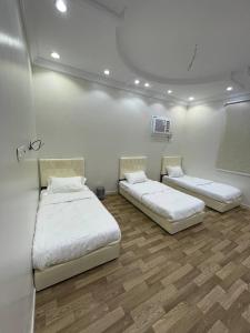 a room with two beds and a tv on the wall at وحدات صروح الفاخرة in Medina