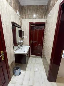 a bathroom with a sink and a red door at وحدات صروح الفاخرة in Medina